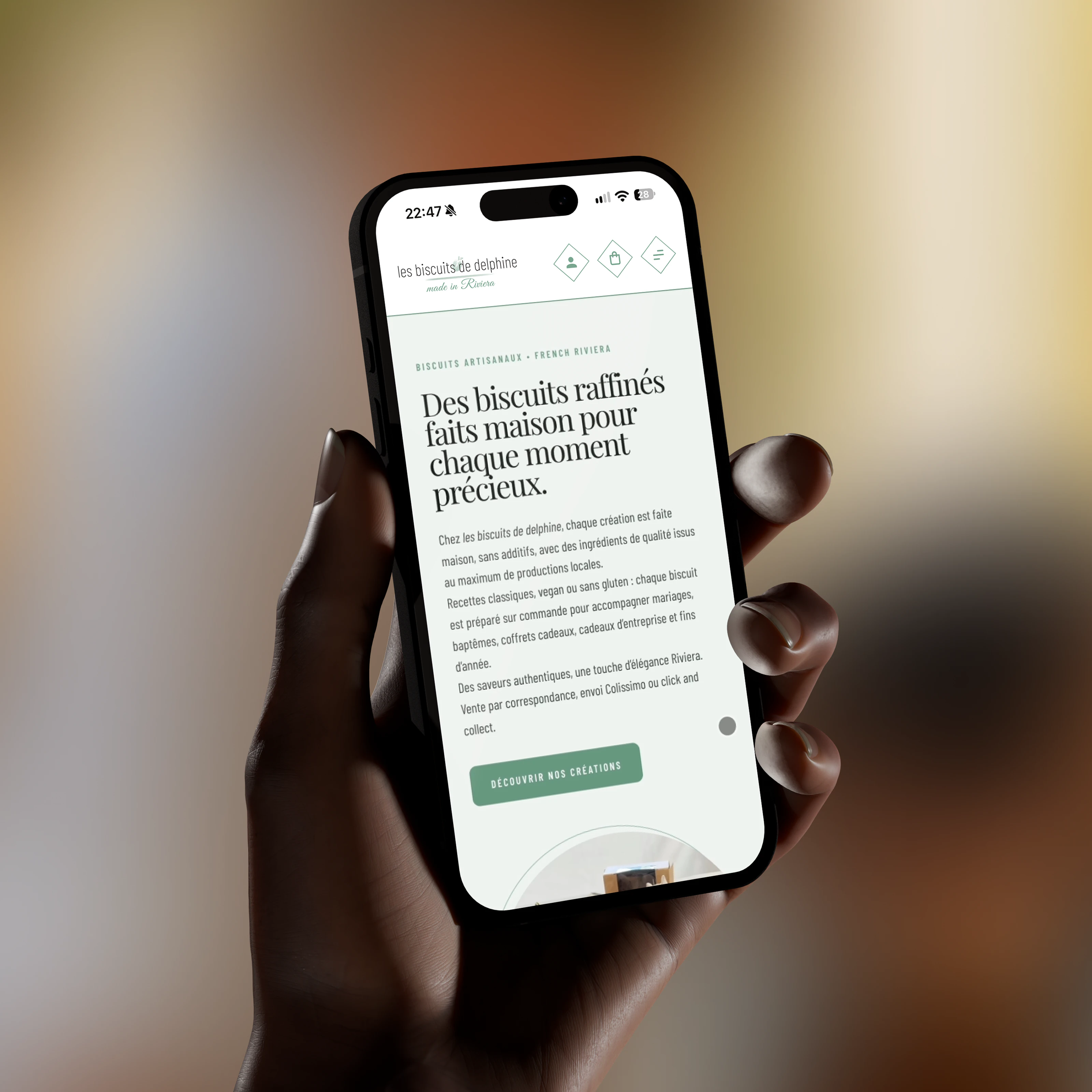Les Biscuits de Delphine : page d’accueil du site sur un téléphone tenu en main